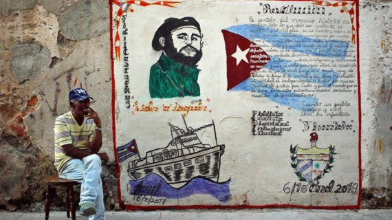 Cubano frente a un mural político sobre Fidel Castro. Foto: EFE